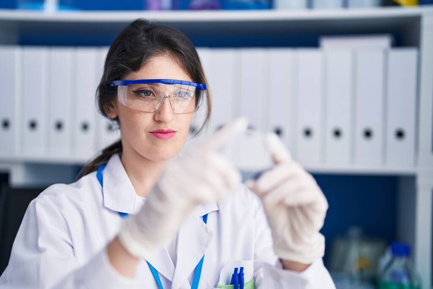 Mladý hispánec žena vědec hledá vzorek v laboratoři - Fotografie, Obrázek