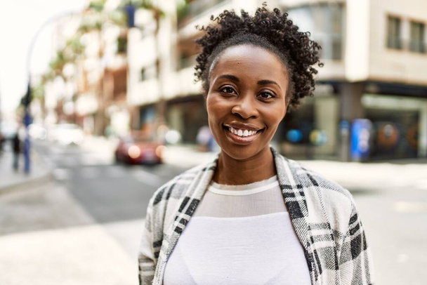 jong Afrikaans amerikaans meisje glimlachen gelukkig staan in de stad. - Foto, afbeelding