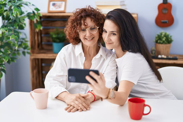 Dvě ženy matka a dcera dělat selfie podle smartphone doma - Fotografie, Obrázek