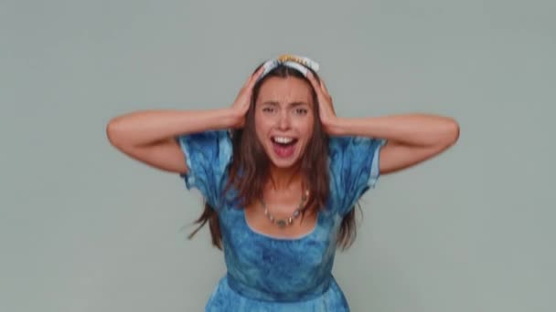Angry sad young woman screams from stress tension problems feels horror hopelessness fear surprise shock expresses gestures rage. Adult stylish girl isolated alone on gray studio background indoors - Imágenes, Vídeo
