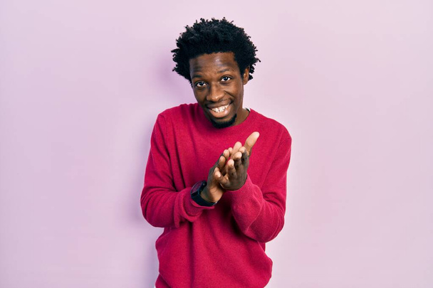 Mladý africký Američan nosí ležérní oblečení tleskání a tleskání šťastný a radostný, usmívající se hrdé ruce dohromady  - Fotografie, Obrázek