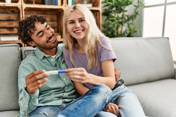 Молода пара посміхається щасливий вигляд результату тесту вагітних вдома
. - Фото, зображення