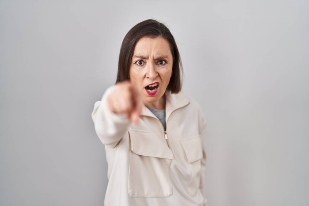Middle age hispanic woman standing over isolated background pointing displeased and frustrated to the camera, angry and furious with you  - Photo, Image