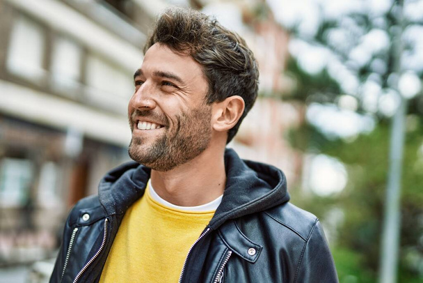 Hombre hispano guapo con barba sonriendo feliz al aire libre - Foto, imagen