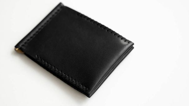Brown mens money clip handmade leather wallet. Empty money clip wallet with a two pockets for cards lies on a white table. Selective focus, copy space - Foto, Imagem