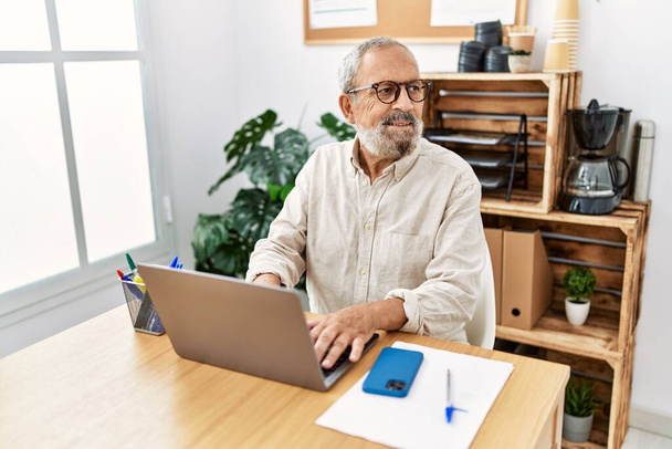 Älterer grauhaariger Mann lächelt selbstbewusst im Büro - Foto, Bild