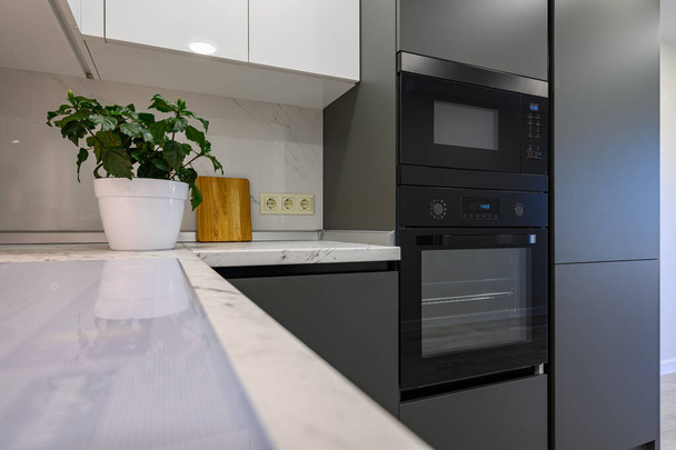 Closeup to marble worktop of modern dark grey and white kitchen - Photo, Image