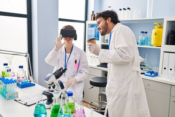 Мужчина и женщина-учёные партнёры используют защитные очки и пьют кофе в лаборатории - Фото, изображение