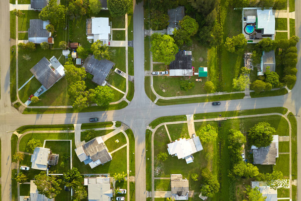 Aerial landscape view of suburban private houses between green palm trees in Florida quiet rural area at sunset. - 写真・画像