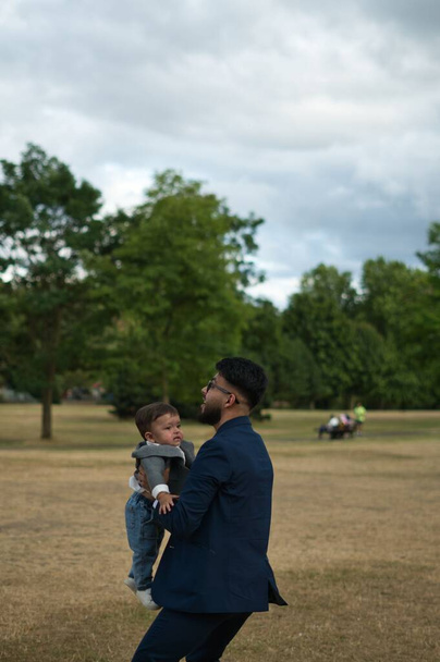 Asian Pakistani Father is holding his 11 Months Old Infant at Local Park of London Luton England UK - 写真・画像