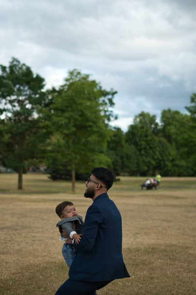 Asian Pakistani Father is holding his 11 Months Old Infant at Local Park of London Luton England UK - 写真・画像