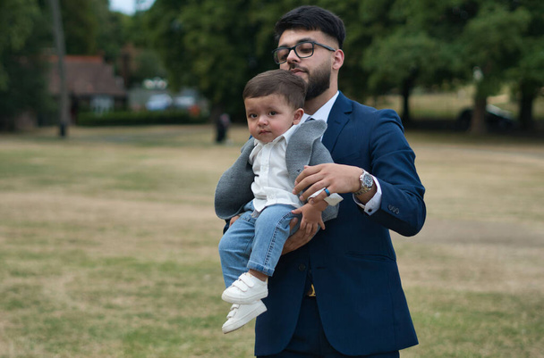 Asian Pakistani Father is holding his 11 Months Old Infant at Local Park of London Luton England UK - Φωτογραφία, εικόνα