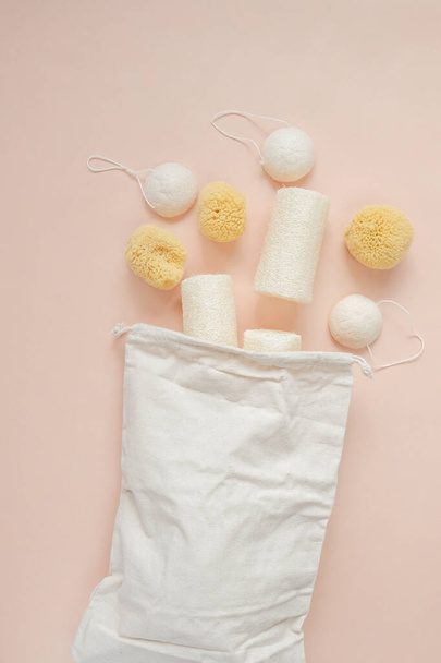 Zero waste products set.Natural cognac sponges and loofah washcloths and a beige cotton bag on a beige light background.Eco friendly bio natural cosmetics.reasonable consumption  - 写真・画像