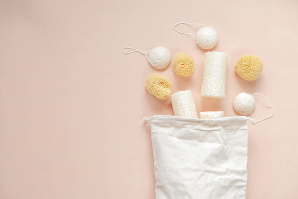 Zero waste. cognac sponges and loofah washcloths and a beige cotton bag on a beige light background.Eco friendly bio natural cosmetics.reasonable consumption  - Foto, imagen