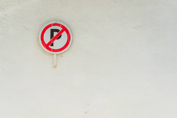 No parking sign on a white wall. small parking sign in tourist city. - Photo, image