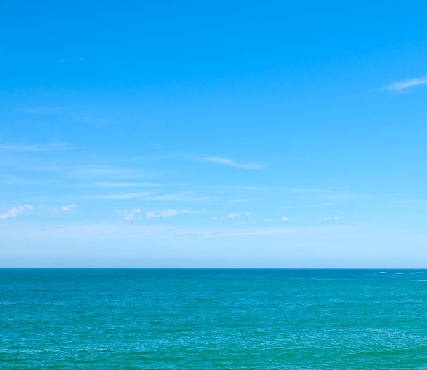 Beautiful, calm and quiet view of the beach, ocean and sea against a clear blue sky copy space background on a sunny day. Peaceful, scenic and tranquil landscape to enjoy a relaxing coastal getaway. - Фото, изображение