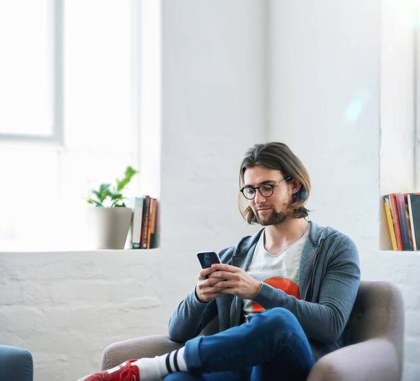 Mladý muž používající smartphone doma textové čtení zpráv sociálních médií procházení on-line. - Fotografie, Obrázek