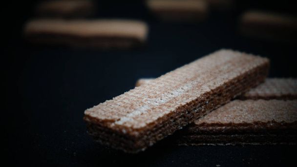 Sweet wafers on black background, flat lay. Sweet food. Background texture - 写真・画像