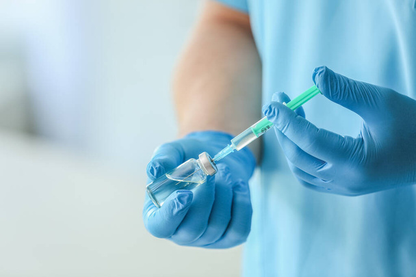 Doctor with ampule and syringe in clinic, closeup - Foto, afbeelding