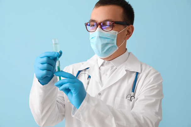 Doctor with ampule and syringe on light blue background - Foto, Imagem