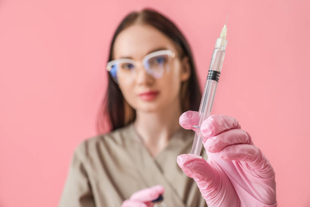 Doctor with syringe on pink background, closeup - Fotoğraf, Görsel