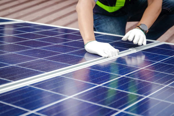 Asiatische Techniker installieren Solarzellen, um Strom zu produzieren und zu verteilen. Energietechnologiekonzept. Kopierraum - Foto, Bild