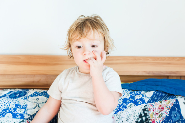 Εσωτερική πορτρέτο του ένα χαριτωμένο μικρό παιδί αγόρι που δαγκώνει τα νύχια - Φωτογραφία, εικόνα
