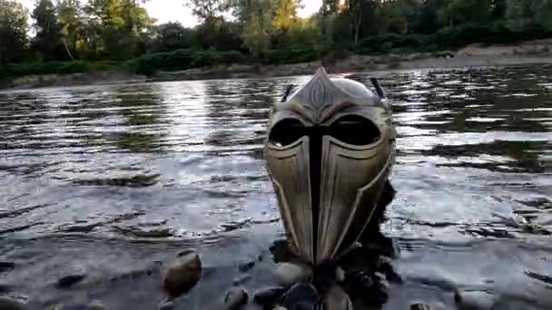 Metaphorical installation on a mountain river with a gladiatorial helmet - Кадры, видео