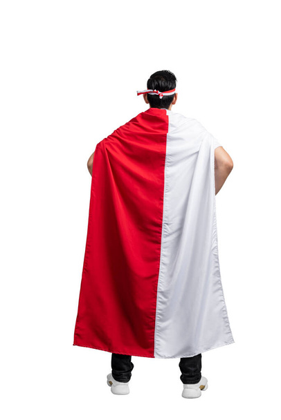 Rear view of Indonesian men celebrating Indonesian independence day on 17 August by holding the Indonesian flag isolated over white background - Photo, Image