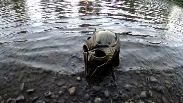 Metaphorical installation on a mountain river with a gladiatorial helmet - Imágenes, Vídeo