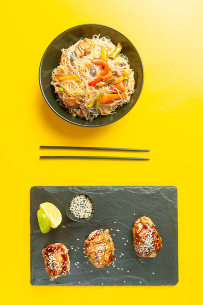eten Aziatische keuken. Aziatische of Szechuan noedels. Chinese wok noedels in een kom met groenten en teriyaki kip. - Foto, afbeelding