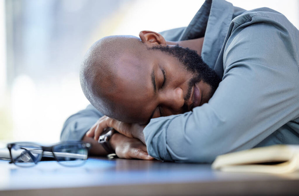 We hebben allemaal rust nodig. een jonge zakenman die in een kantoor op het werk slaapt - Foto, afbeelding