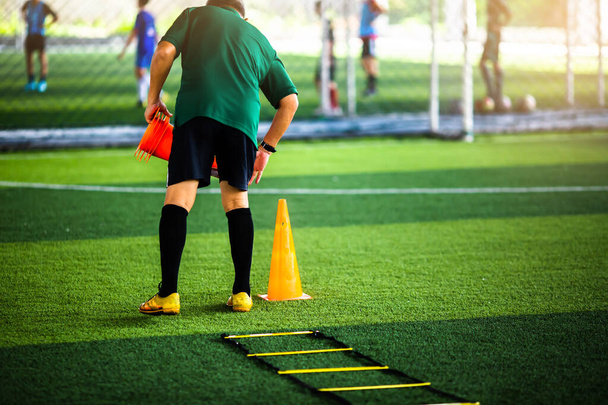 Trainer setzt die Markierungskegel für das Fußballtraining zum Laufen und Springen. Fußballakademie. - Foto, Bild