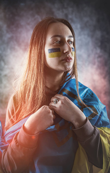 donna avvolta in una bandiera ucraina piange per la guerra iniziata dalla Russia. Pregate per l'Ucraina e sperate nella pace e nel mondo - Foto, immagini