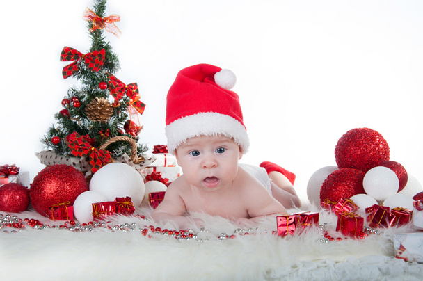 Noel Baba'nın şapkalı bir Noel ağacın arkasına ile şirin bebek - Fotoğraf, Görsel