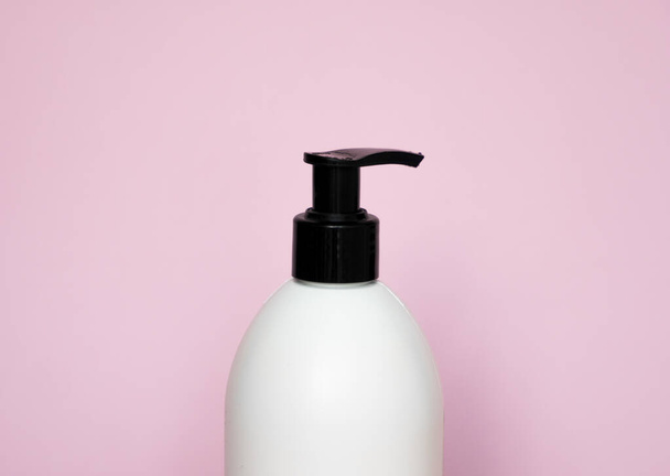 White plastic soap dispenser pump bottle isolated on pink background. Skin care lotion. Bathing essential product. Shampoo bottle. Bath and body lotion. Fine liquid hand wash. Bathroom accessories - Foto, Imagem