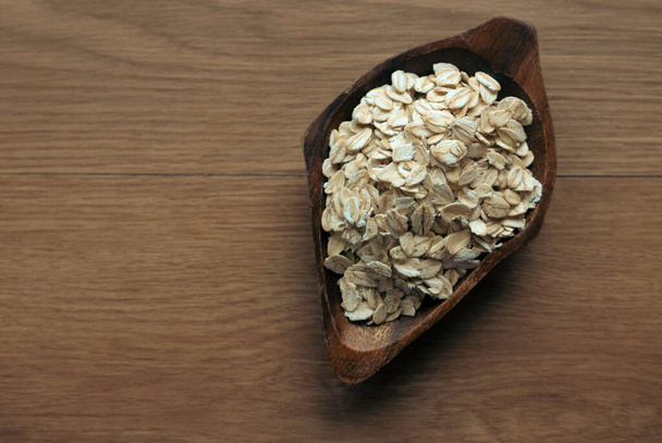 Rolled oats on a wooden bowl. - Photo, Image