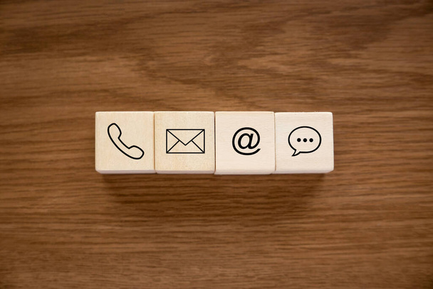 Variety of contact approach. Icon of phone, email, post and chat on a wooden cube. - Foto, Imagen