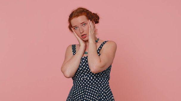 Woman feeling hopelessness and loneliness, nervous breakdown, loses becoming surprised by lottery results, bad fortune, loss, unlucky news. Ginger girl with freckles isolated on pink studio background - Photo, Image