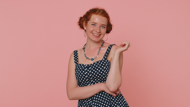 Cheerful lovely redhead young woman in black dress smiling, looking at camera, flirting. Adult fashion red hair model girl indoors studio shot isolated on pink background. Female nature beauty - Foto, Imagen