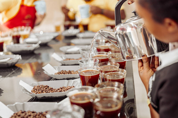 Cropped photo of female employee pouring water from kettle for coffee tasting in production - Foto, Imagem