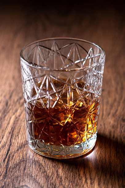 Scotch whiskey glass, on wooden table - Фото, изображение