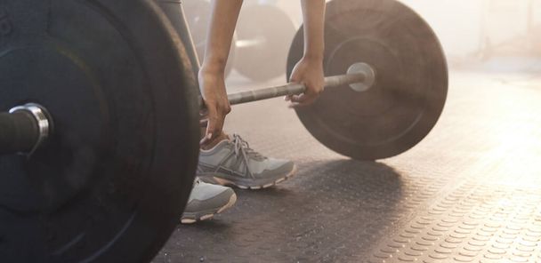 Deadlifts target full-body activation. Closeup shot of an unrecognisable woman exercising with a barbell in a gym - Φωτογραφία, εικόνα