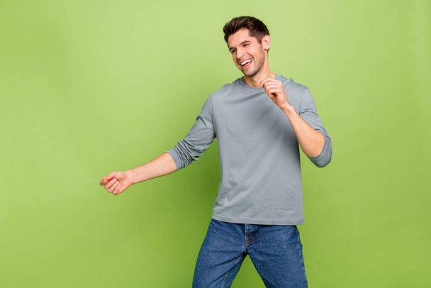 Photo of good mood laughing male enjoy dancing party with his girlfriend wear blue pullover isolated on green color background. - Foto, afbeelding
