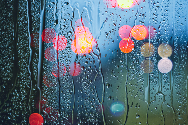 drops on the window and street lights background  - Фото, изображение
