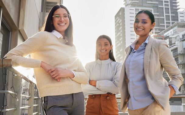 Were going places. Cropped portrait of three attractive young businesswomen standing on an office balcony - Foto, Imagen