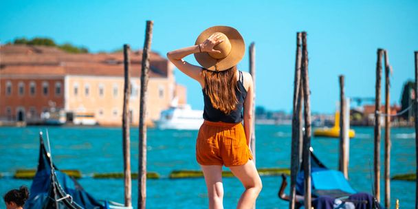 Young woman in a straw hat against the backdrop of the Venetian canals - 写真・画像