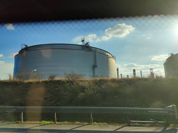 Oil storage tank terminal and tanker, petrol industrial zone shot from a moving car. - Φωτογραφία, εικόνα