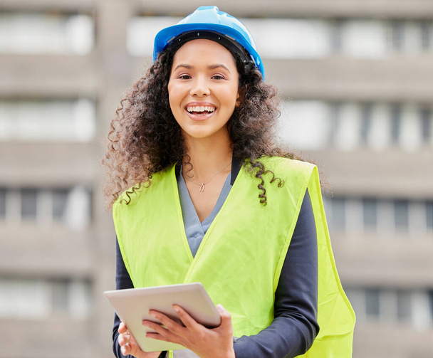 Im on top of this building project. Cropped portrait of an attractive young female engineer working on a tablet while standing on a construction site - Photo, image