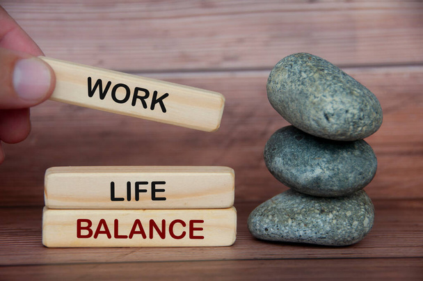 Work life balance text on wooden blocks with rocks and wooden cover background. New ways of working concept - 写真・画像